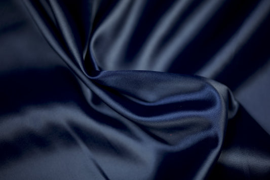 Satinstoff in edlem Nachtblau mit weichem Glanz und eleganter Faltenstruktur – ideal für Abendmode und klassische Dekorationen